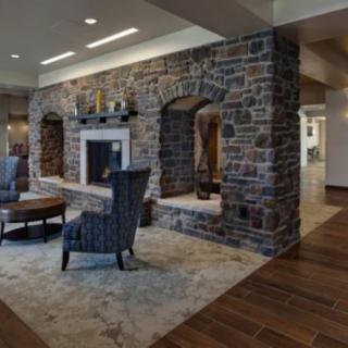 A cozy living room featuring a stone fireplace and comfortable seating.
