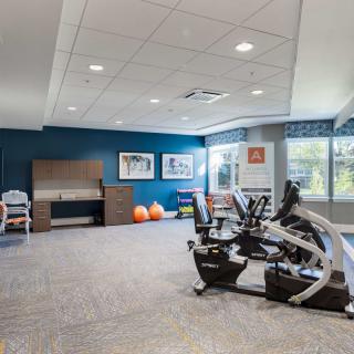 A modern fitness room with exercise equipment and bright decor.