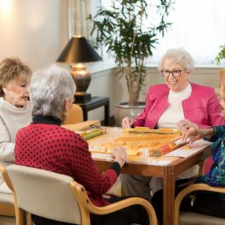 A group of seniors enjoying a card game together in a cozy indoor setting.