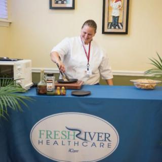 A chef conducting a cooking demonstration at a Fresh River Healthcare event.