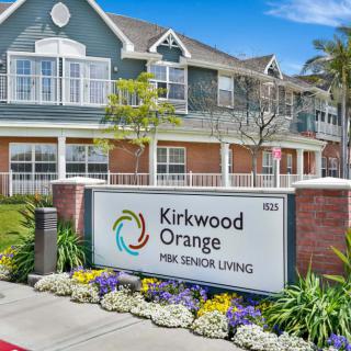 Kirkwood Orange Park Senior Living facility entrance with a landscaped garden and sign.