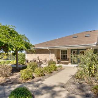 A cozy house with a well-maintained garden and pathway under a clear blue sky.