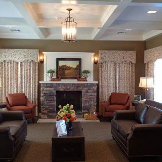A cozy living room with a fireplace, surrounded by comfortable seating and elegant decor.