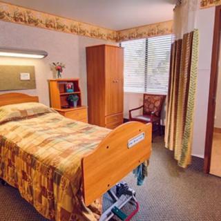 A well-organized healthcare room with a bed and furniture.