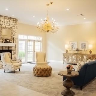 A spacious and elegantly decorated living room with a chandelier and fireplace.