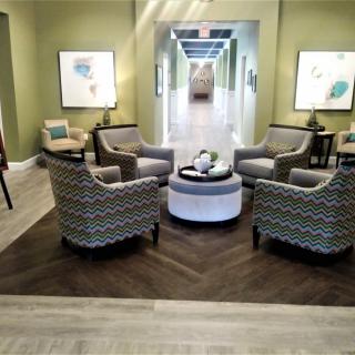 A modern living room with a cozy seating area featuring four armchairs and a central coffee table.