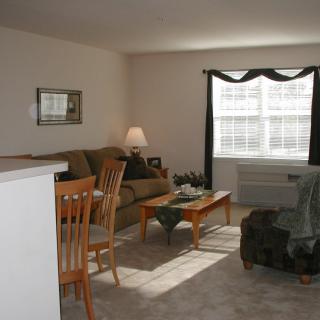 A cozy living room with a sofa, coffee table, and large window.