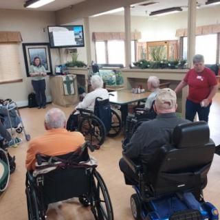 A group of seniors attending a presentation in a community center.