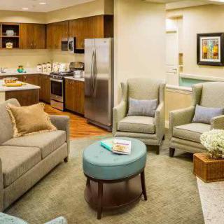 A modern living room with an open-plan kitchen, featuring comfortable seating and stylish decor.
