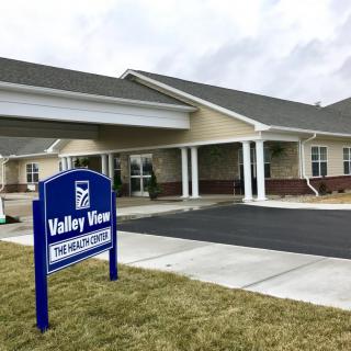 A building with a sign for Valley View, featuring a covered entrance and parking area.