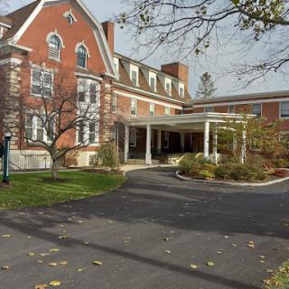 A view of a charming brick building surrounded by greenery and trees.