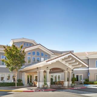 A modern residential building with an inviting entrance under a clear blue sky.