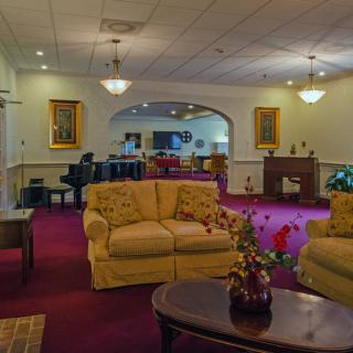 A cozy living room featuring comfortable sofas, a piano, and elegant decor.