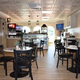 A modern cafe interior with tables and chairs arranged for seating.
