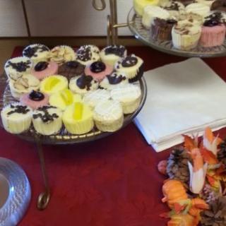 A variety of colorful cupcakes displayed on a tiered stand at a buffet.