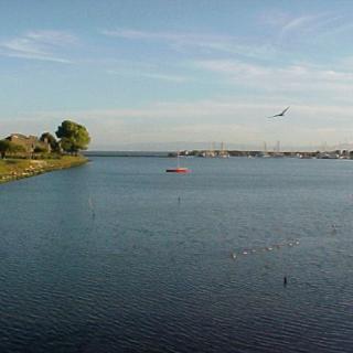A serene view of a lake with boats and a clear sky.