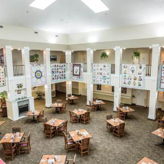 A spacious dining area with tables, chairs, and decorative elements on the walls.