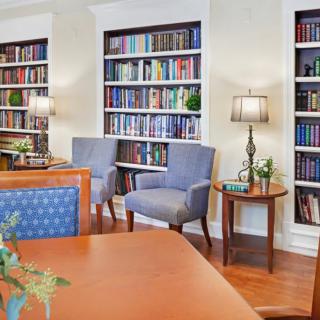 A cozy library with shelves filled with books, comfortable seating, and soft lighting for a perfect reading environment.