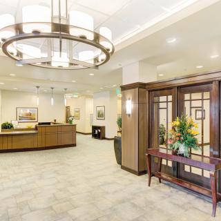 A spacious and elegantly designed lobby with a large reception desk and modern lighting.