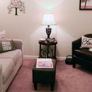 A cozy living room with a sofa, lamp, and decorative pillows.