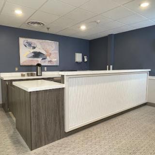 A modern reception area featuring a sleek counter and contemporary artwork on the wall.