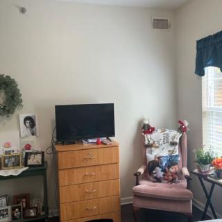 A cozy living room corner with a dresser and chair adorned with decorations.
