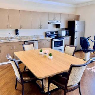 A modern kitchen and dining area featuring a wooden table, chairs, and various appliances.