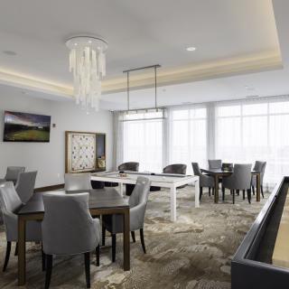 A modern dining room with elegant furniture and decorative lighting.