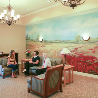 A cozy waiting area with comfortable seating and a scenic mural on the wall.