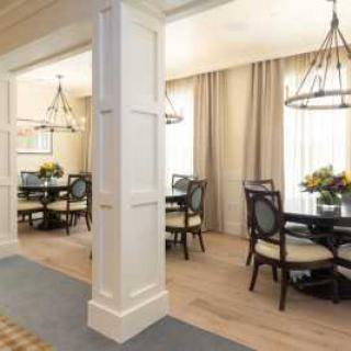 A modern dining area with elegant furnishings and chandeliers.