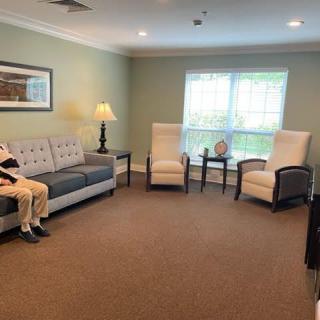 A cozy living room with a sofa, chairs, and warm lighting.