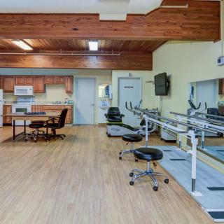 A spacious rehabilitation room equipped with exercise and therapy equipment.