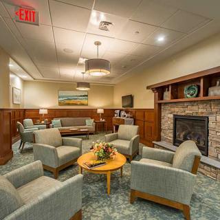A cozy waiting room with comfortable seating and a fireplace.