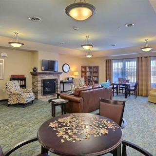A cozy living room with modern furniture, featuring a fireplace and a television.
