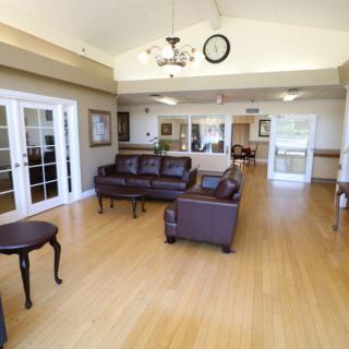 A spacious lobby area with leather sofas and wooden flooring.