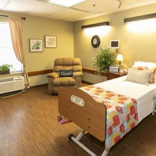 A cozy bedroom with a hospital bed and comfortable seating area.
