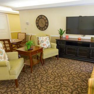 A cozy living room featuring comfortable seating, a large TV, and tasteful decorations.