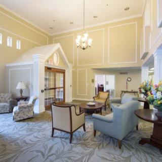 A well-lit living area featuring comfortable seating, a chandelier, and elegant decor.