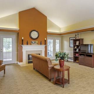 A spacious living room with a sofa, fireplace, and television.