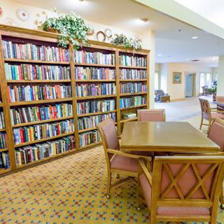 A cozy library with bookshelves and a reading table.