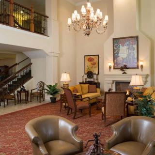 A luxurious hotel lobby featuring elegant seating, a grand chandelier, and a cozy fireplace.