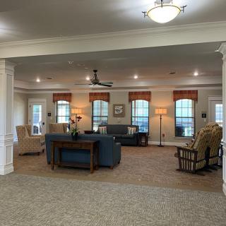 Spacious and elegantly furnished living room with ample seating and natural lighting.