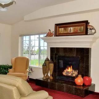 A cozy living room with a fireplace, armchair, and elegant decor.