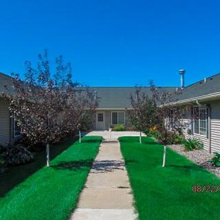 A well-maintained courtyard with a central pathway, surrounded by residential buildings and lush greenery.