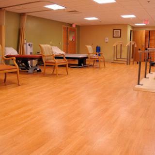 A spacious rehabilitation room featuring comfortable seating and a warm, inviting atmosphere.