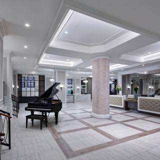 A modern luxury lobby featuring a grand piano and elegant interior design.