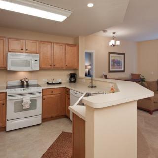 A modern kitchen with wooden cabinets and standard appliances.
