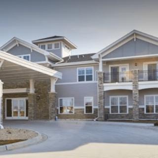 A modern residential building with a driveway and covered entrance.