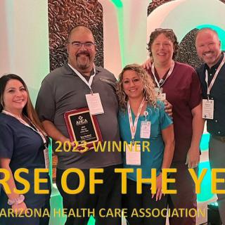 A group of people celebrating the 'Nurse of the Year' award at the Arizona Health Care Association event.