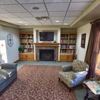 A cozy living room with a fireplace, bookshelves, and comfortable seating.